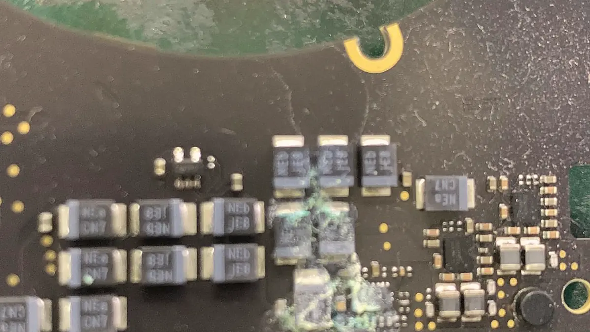 A logic board power section, with corrosion around a group of capacitors