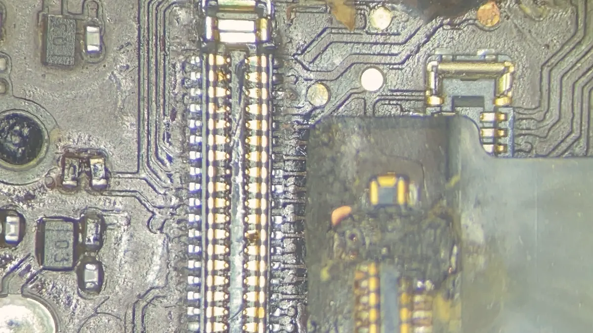 Board connectors under the microscope, one with burnt contacts