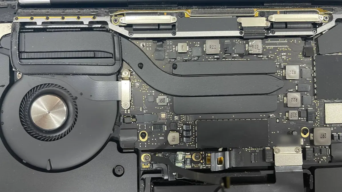 Inside an opened MacBook, showing the fan, the heat pipe, the logic board and the battery